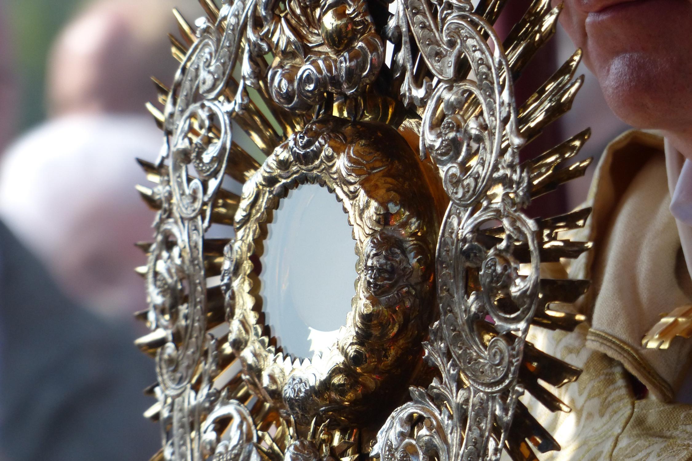 Vergoldete Monstranz mit filigranen Verzierungen in einer religiösen Zeremonie.